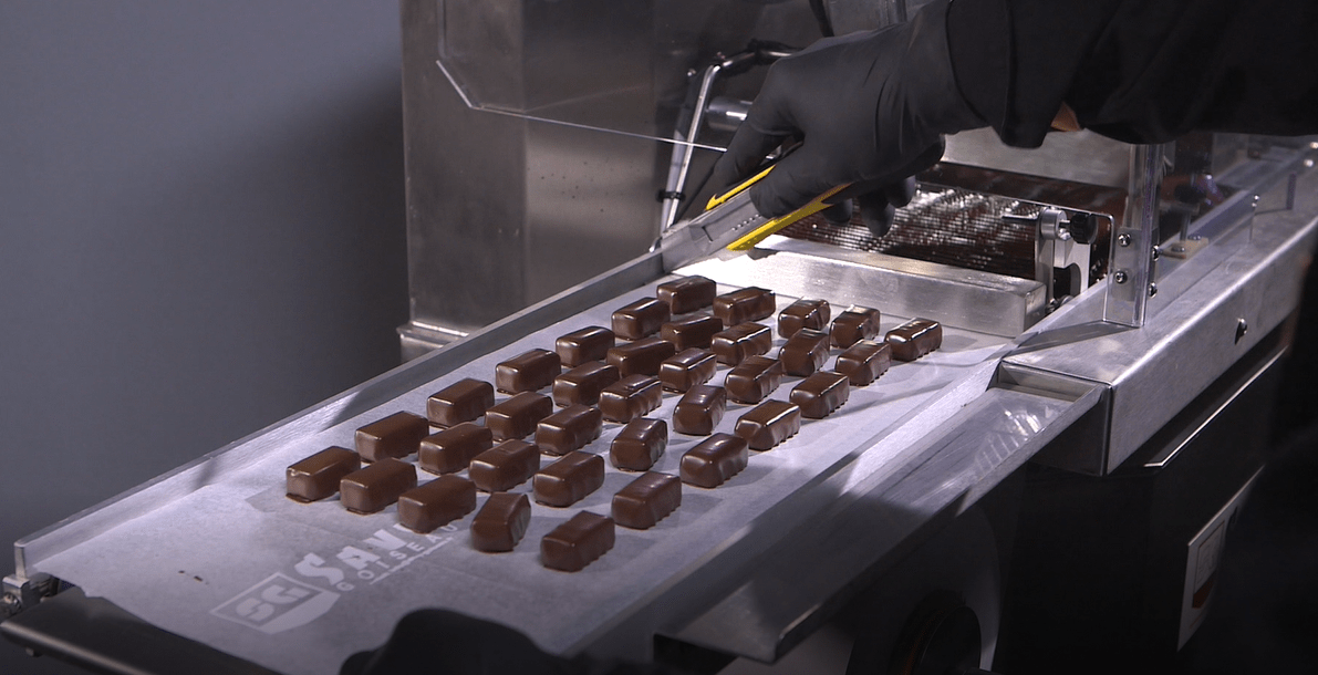 Enrobing paper on the outfeed conveyor of a chocolate enrober